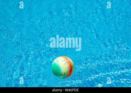 Boule colorée flottant sur une surface de la piscine. Banque D'Images