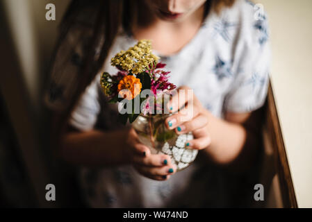 Petite fille fait un bouquet de fleurs dans la cuisine Banque D'Images