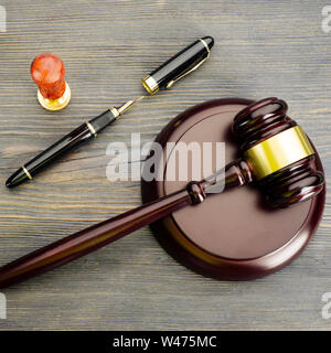 Judge's gavel, stylo et d'un timbre sur une vieille table en bois - Image Banque D'Images