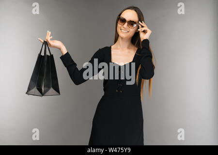 Le vendredi noir vente concept. Woman holding Shopping bag isolated on contexte en maison de vacances - Image Banque D'Images