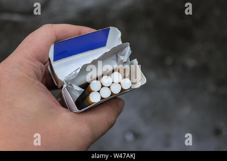 Un paquet de cigarettes dans ses mains. Atteinte à la santé des fumeurs. Banque D'Images