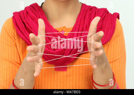 Woman doing cat cradle Stock Photo