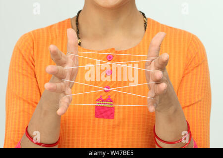 Woman doing cat cradle Stock Photo