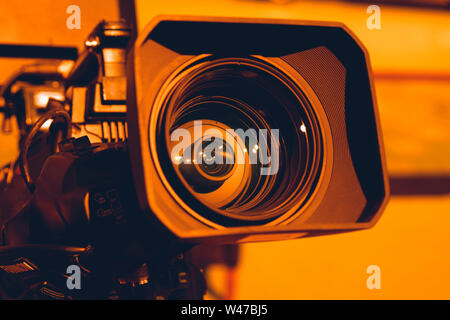 Caméra vidéo sur la grue mène tournage d'un mariage dans la salle des fêtes contre l'arrière-plan de feux multicolores.Close-up. Banque D'Images