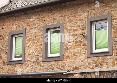 Trois fenêtres avec des volets verts dans un mur de brique (Allemagne, Europe) Banque D'Images