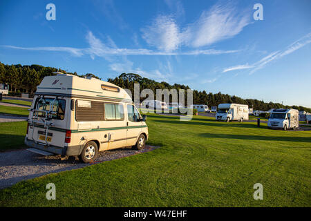 Soleil de fin de soirée avec camping-cars et caravanes sur un camping dans le Nord du Pays de Galles UK Banque D'Images