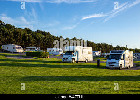 Soleil de fin de soirée avec camping-cars et caravanes sur un camping dans le Nord du Pays de Galles UK Banque D'Images