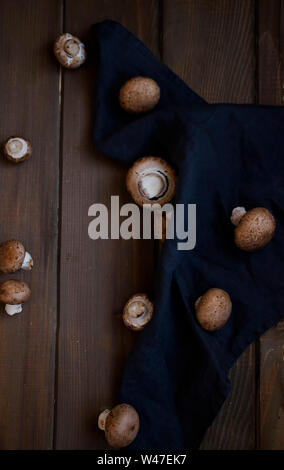 Peu de champignons brun noir sur fond rustique en bois sur serviette. Banque D'Images