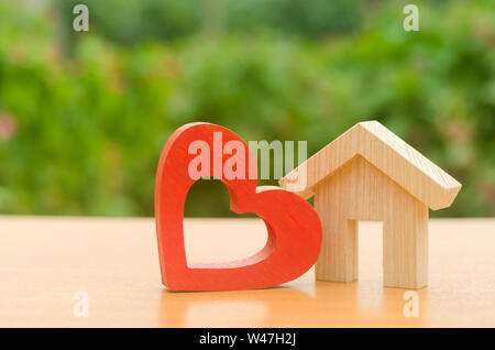 Maison avec un coeur en bois rouge. Chambre des amoureux. Le logement abordable pour les jeunes familles, programme de soutien. Accueil chaleureux des parents. La construction de logements Banque D'Images