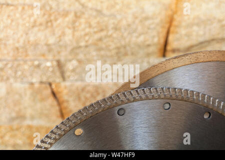 Disques de coupe en argent de segment dans le contexte d'un mur de grès doré à l'orange en gros plan. Banque D'Images