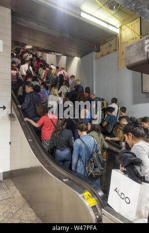 Les gens monter les escalators jusqu'à partir de la station de métro à l'heure de pointe au cours de la soirée en Grand Central Terminal pour prendre le train home hors de la ville. Banque D'Images