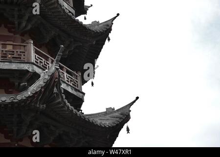 Profil d'un balcon et l'a fait en bois décoré, toits de pagode chinoise traditionnelle. Poisson modèle pendaison en silhouette. Banque D'Images