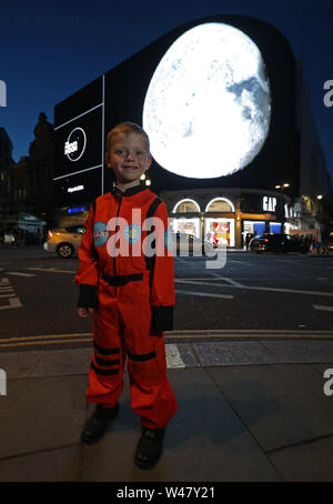 Archie Crowson, 5, de Stamford, Lincolnshire, se dresse en face de Londres l'artiste Helen Marshall's People's Moon project, une mosaïque photographique géant présenté à l'heure exacte il y a 50 ans qu'Apollo 11 s'est posé la première des gens sur la Lune, à Piccadilly Circus, Londres. Banque D'Images