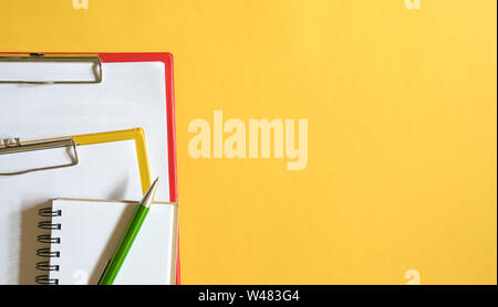 Les presse-papiers, bloc-notes et stylo vert sur fond jaune ou top 24. Copy Space Banque D'Images