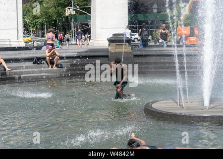 New York, NY - 20 juillet 2019 : les New-yorkais refroidir dans Washington Square fontaine vague de chaleur extrême et de la température de la ville a frappé atteint 105 degrés Fahrenheit (40 degrés Celsius) Banque D'Images