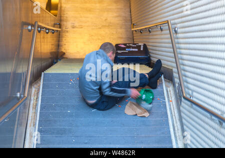 Un sans-abri dans les escaliers du métro avec des aiguilles, San Francisco, California, USA Banque D'Images