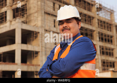 Portrait d'un architecte avec ses bras croisés à la construction site Banque D'Images