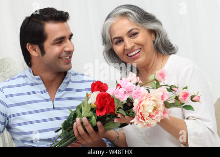 Homme donnant un bouquet de fleurs à sa mère Banque D'Images