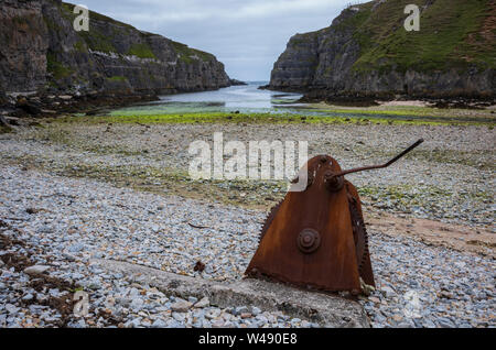 Rusty, un morceau de machiney abandonnés qui a engrenages, repose sur une plage rocheuse à Geodha à Smoo Cave Smoo, une grande cave et d'eau douce mer combiné cave Banque D'Images