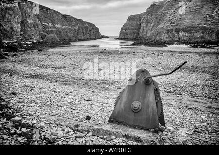 Rusty, un morceau de machiney abandonnés qui a engrenages, repose sur une plage rocheuse à Geodha à Smoo Cave Smoo, une grande cave et d'eau douce mer combiné cave Banque D'Images
