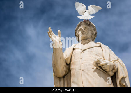 Oiseau blanc assis sur le dessus de l'ancienne statue de Dionysios Solomos dans Zakythos Town Square, Grèce Banque D'Images