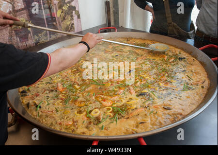 Le chef prépare avec des fruits de mer, paella, moules, crevettes et haricots verts dans une très grande poêle. Banque D'Images