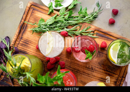 Les boissons d'été, un ensemble de limonades. Les limonades dans pichets sur la table, les ingrédients qui les composent sont disposés autour. Banque D'Images