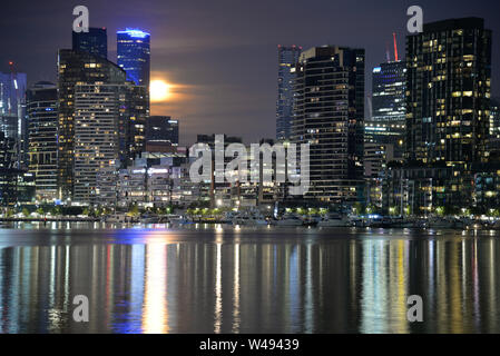 Nuit paysage urbain et du port de la réflexion avec la pleine lune qui reflète sur Victoria Harbour Docklands Melbourne Australie Victoria Banque D'Images