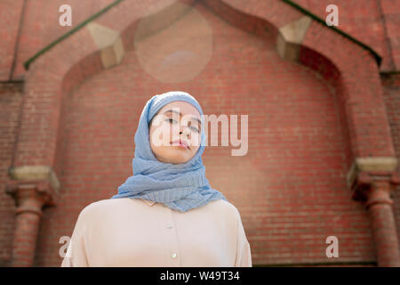 Jeune femme musulmane en hijab par permanent de mur oriental palace Banque D'Images