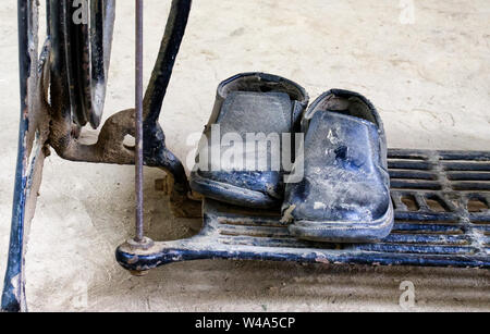 Couvertes de poussière sur des cales sur le plancher d'une vieille machine à coudre Banque D'Images