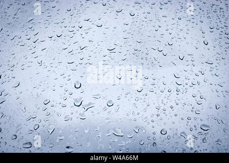 Grosses gouttes d'eau sur la vitre. Gouttes de pluie sur le pare-brise d'une voiture sur le fond du ciel ciel. Banque D'Images