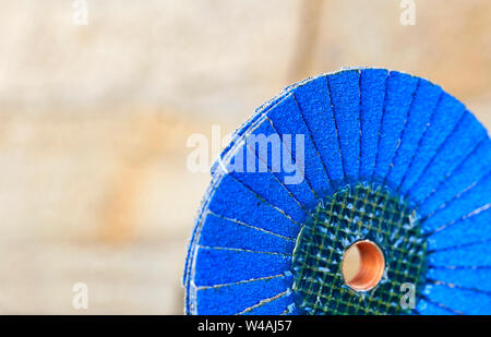 Une partie d'une meule de pétale de couleur bleue pour le ponçage du bois et métal rouillé sur un fond beige clair en imprécision, close-up. Banque D'Images