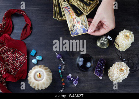 Fortune Teller femmes et Tarots cartes sur table en bois sombre. Concept de divination. Banque D'Images