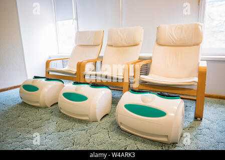 Trois chaises de massage de pied vide dans une enceinte du spa Banque D'Images