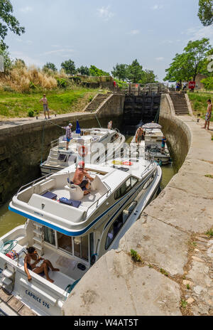 Une écluse sur le canal du midi France un jour d'été avec trois bateaux à moteur en attente que l'écluse se remplisse avant de poursuivre leur voyage Banque D'Images