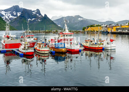 Des bateaux de pêche à la jetée de montagne dans l'arrière-plan à Husoy village, Senja island, Norway Banque D'Images
