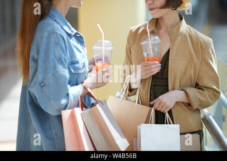 Close-up of young woman avec les sacs en papier faire du shopping avec ami dans mall Banque D'Images