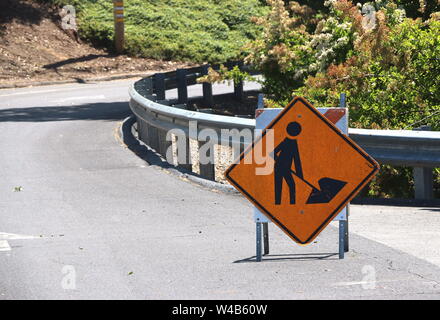 Panneau de signalisation jaune et noir avec l'homme avec une pelle, avertissement de travaux routiers à venir. Banque D'Images