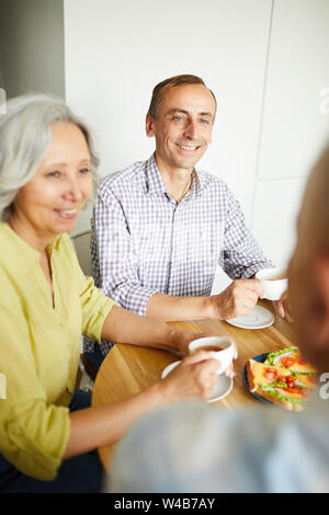 Portrait of smiling young man sitting at table de dîner avec vos amis et votre famille, copy space Banque D'Images