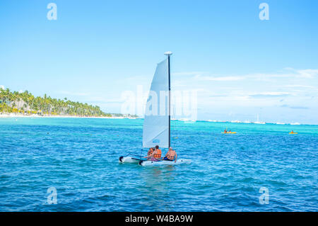 Punta Cana, République dominicaine - le 26 octobre 2018 : Les gens nager sur un yacht au milieu des palmiers dans la station balnéaire de Punta Cana. Banque D'Images