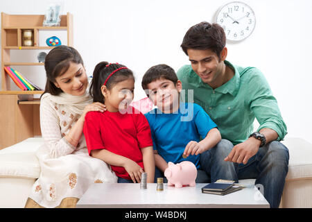 Les parents aident leurs enfants à économiser de l'argent Banque D'Images