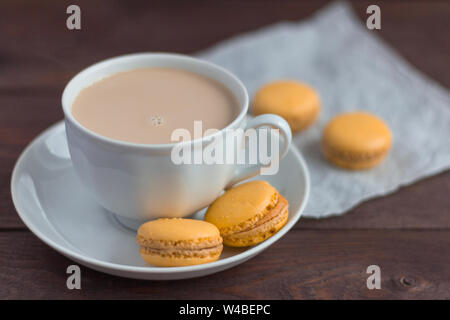 Macarons, de délicieux biscuits aux amandes et une tasse de café avec de la crème sur la table Banque D'Images