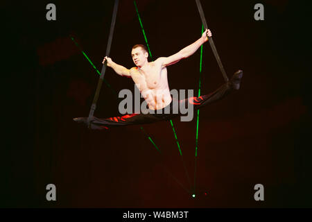 Acrobat effectue un truc difficile dans le cirque. Banque D'Images