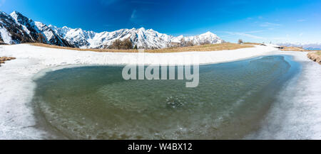 Vue panoramique du Monte Legnone et fusion de glace à l'alpe Piazza pendant le dégel du printemps, Val Gerola, Valtellina, Lombardie, Italie Banque D'Images
