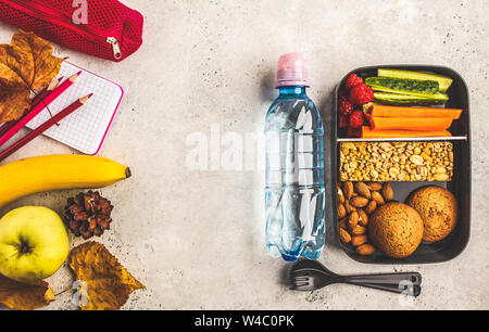 Préparation des repas sains avec des contenants des fruits, des baies, des collations et des légumes. La nourriture à emporter sur fond blanc, vue du dessus. Boîte à lunch à l'école. Banque D'Images