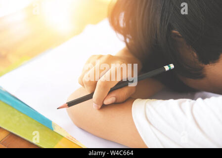 Le stress de l'examen de l'éducation / jeunes femmes college en classe en prenant des notes et en utilisant un concept d'apprentissage séance crayon a souligné l'étudiant asiatique fille prendre ex Banque D'Images