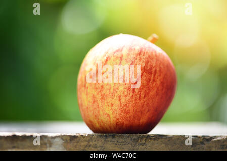 Fresh red apple sur table en bois et nature fond vert dans les fruits d'été Banque D'Images