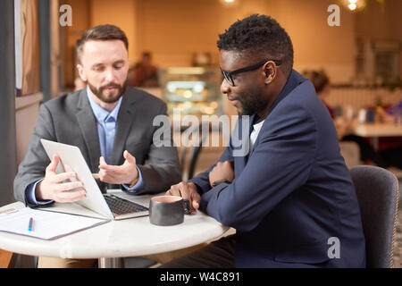 Deux hommes d'avoir un regard sur l'écran de l'ordinateur. Banque D'Images