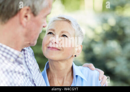 Portrait de senior couple embracing and focus sur d'élégants woman smiling at mari, copy space Banque D'Images