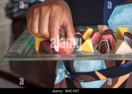 Chocolat pralines vegan colorés en verre sur plateau. Banque D'Images